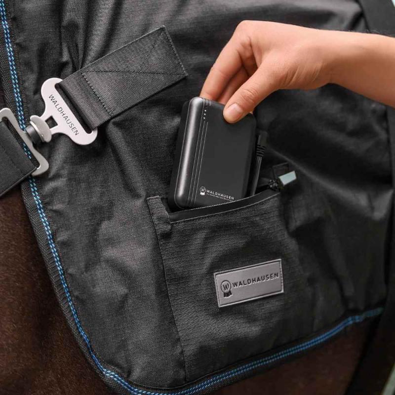 Waldhausen Health and Care Powerbank beim Einsetzen in die Tasche der Pferdedecke